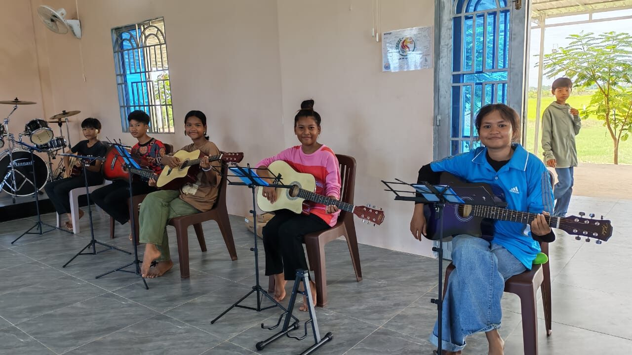 Teenagers playing guitar and singing together during youth ministry