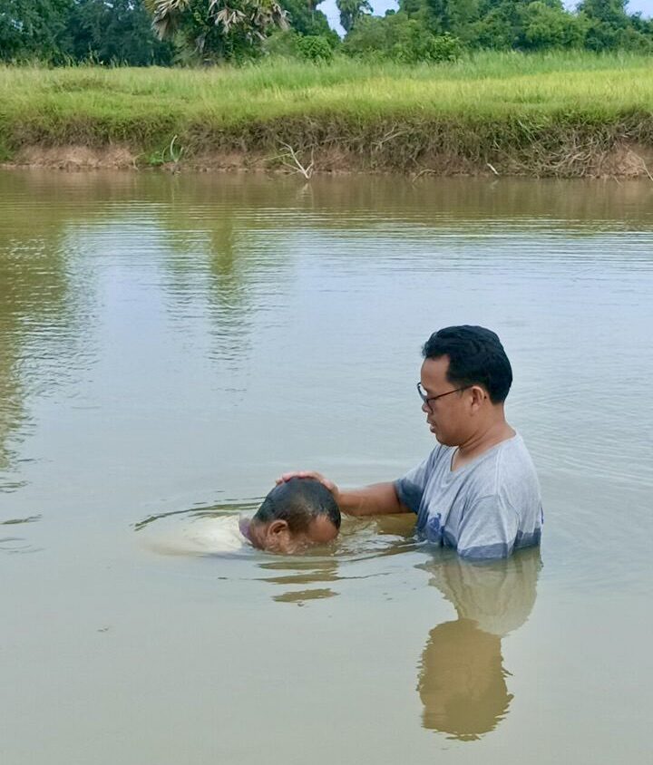 Pastor Sophanna baptizing a new believer in the water
