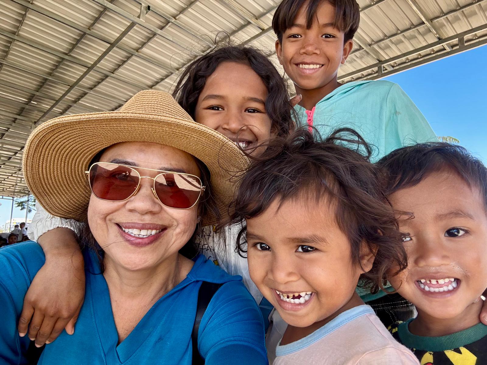Sydney Meth smiling with a group of children in Pursat