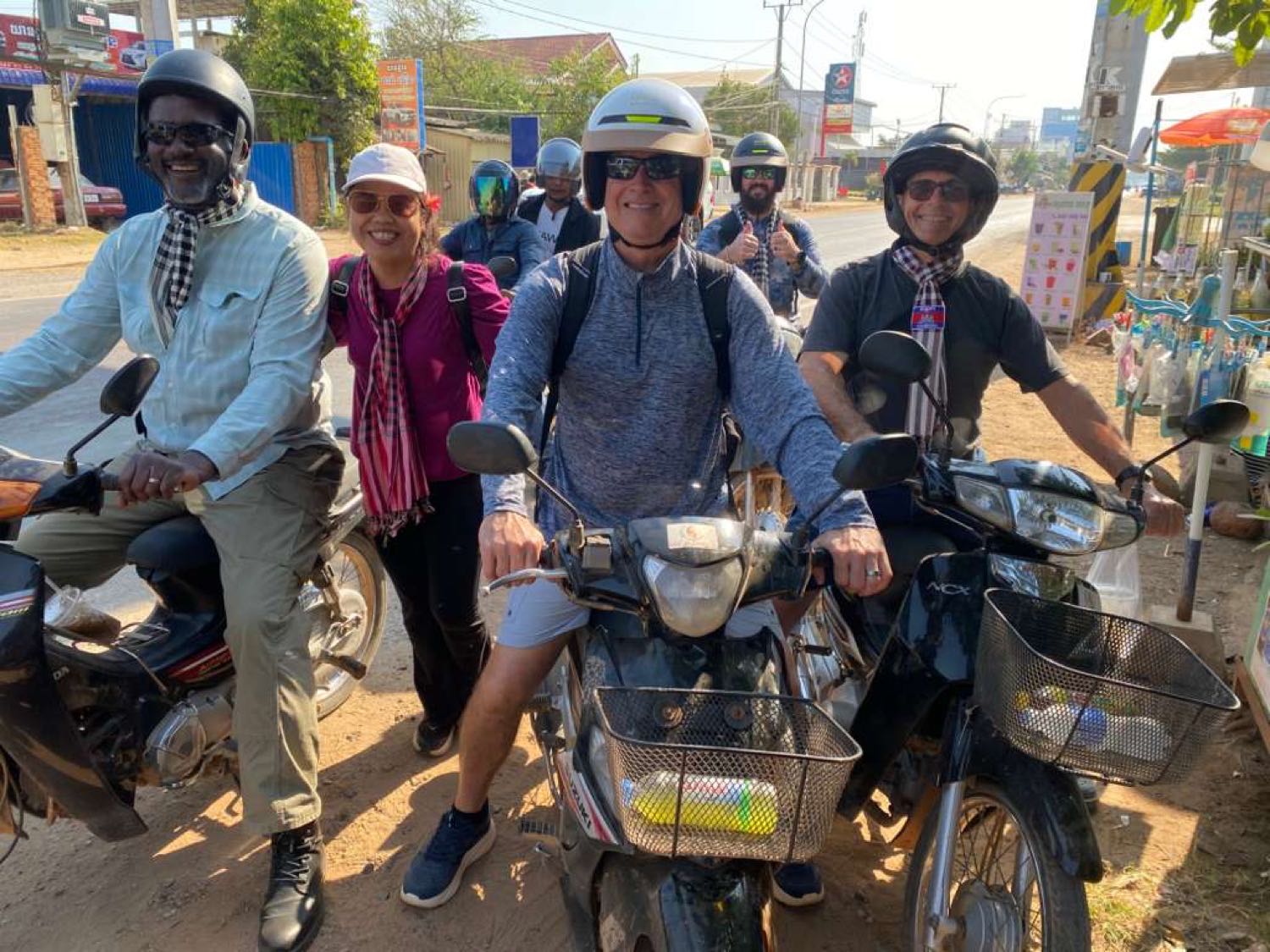 Members of a Light of Cambodia mission team on motorbikes at a roadside in Cambodia