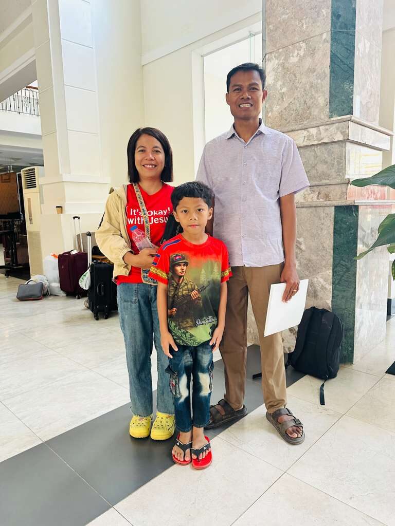 Chan Sreylin and Chan Savin with their family outside their school in Battambang